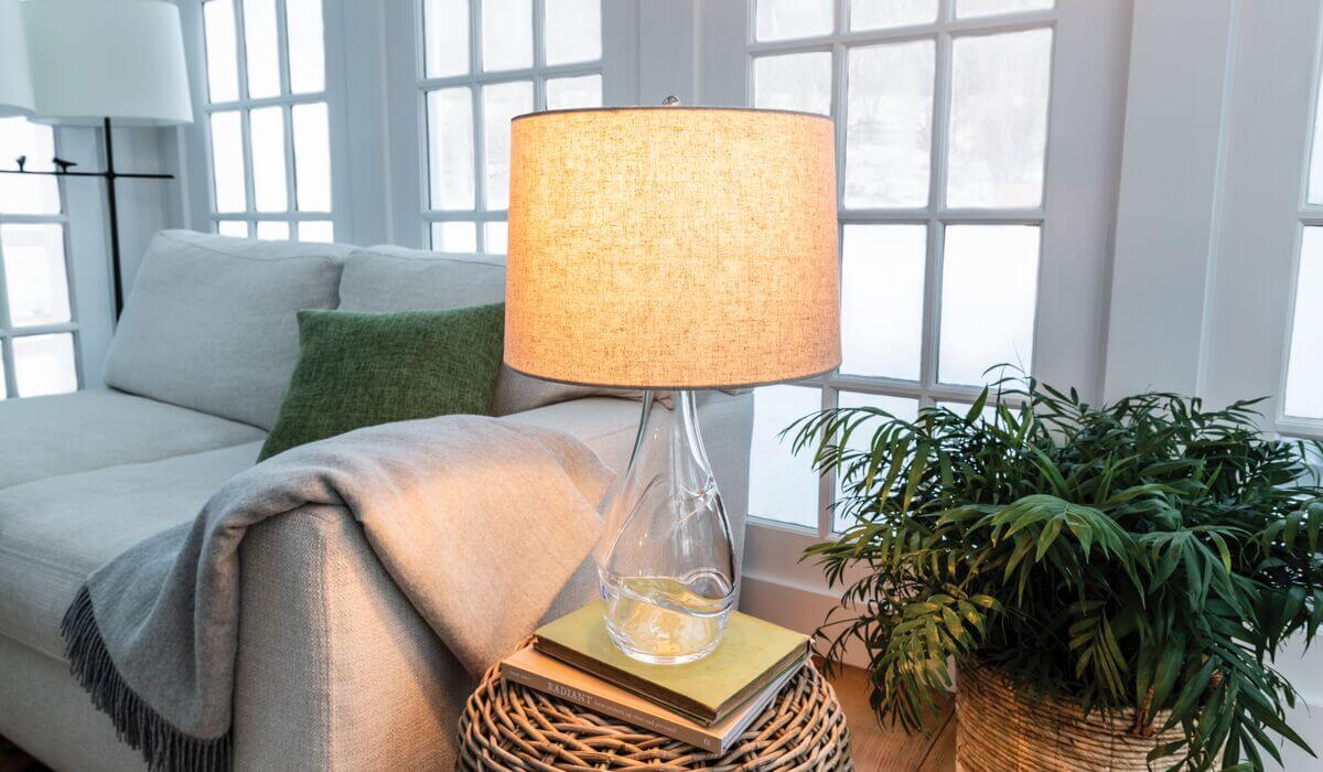 Waterbury Narrow Lamp featured with Linen Barrel Shade - Natural, featured in living room setting with plants